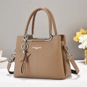 Detail of khaki pebbled leather shoulder bag with star charm and metal chain trim