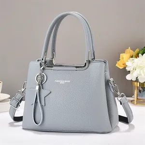 Close-up of light blue pebbled leather handbag with silver hardware and star charm detail