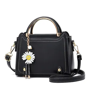 Chic black crossbody handbag with cat-ear shape, gold handles and daisy charm detail