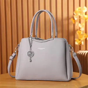 Sac à main élégant pour femme en cuir lavande avec texture et pendentif en métal chic