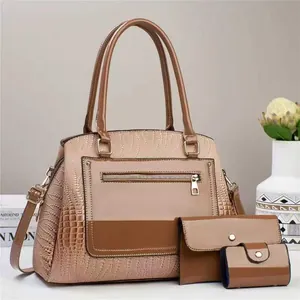 Detail of three-piece tote set with crocodile texture and bicolor faux leather finish