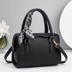 Minimalist black embossed Boston handbag with silk scarf handle and golden hardware