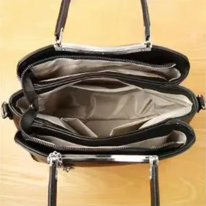 Vue intérieure du sac à main noir avec compartiments zippés et doublure spacieuse