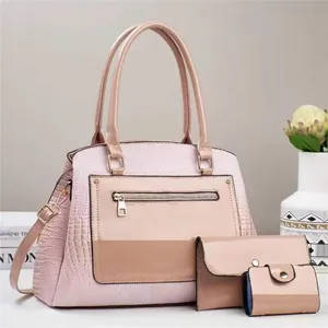 Detailed close-up of pink faux leather bag set with crocodile texture and gold hardware