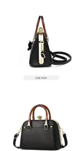 Side view detail of black litchi pattern shell bag with golden hardware and top handle