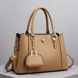 Detailansicht der khakifarbenen Ledertasche mit goldener Hardware und Mini-Anhänger