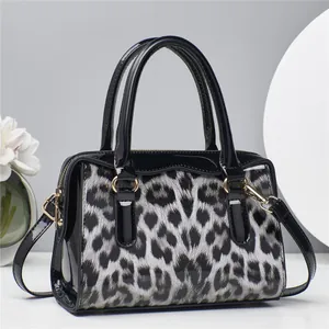 Detail der Handtasche mit Leopardenmuster, schwarzem Lackleder und Goldbeschlägen