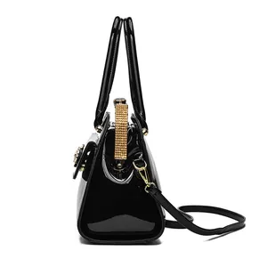 Elegant black patent leather handbag with rhinestone accents and gold hardware