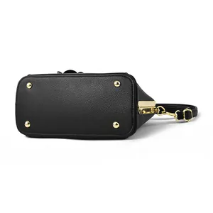 Bottom view of black litchi pattern shell bag featuring four gold protective metal studs