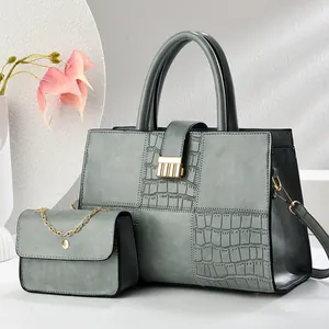 Detail of grey-green tote set with crocodile pattern embossing and gold hardware