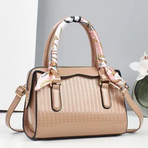 Elegant nude pink embossed patent leather handbag with decorative scarf and shoulder strap