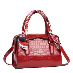 Sac polochon rouge motif crocodile avec poignée foulard et détails métalliques dorés