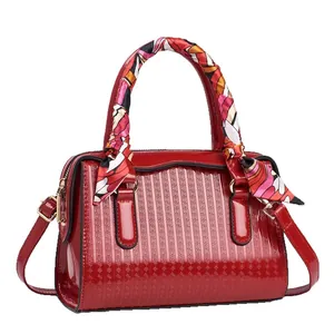 Elegant red embossed patent leather handbag with decorative scarf and detachable strap