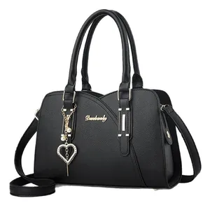 Elegante borsa a mano in pelle nera con ciondolo a cuore e tracolla regolabile