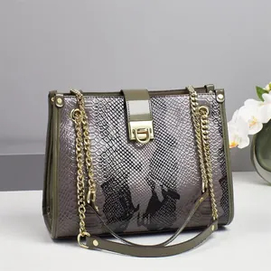 Detailansicht der Handtasche mit Schlangenprägung, Goldkette und Metall-Drehverschluss