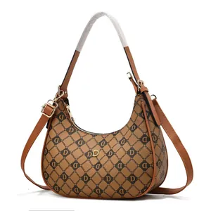 Détail du sac demi-lune marron à monogramme avec finitions métalliques dorées en D