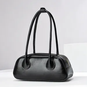 Macro detail of the vintage black leather texture and gold zipper on this baguette bag