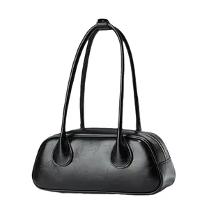 Vintage black faux leather baguette bag with shiny cracked texture and long shoulder strap