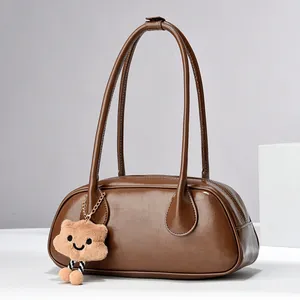 Retro brown semi-cylindrical leather shoulder bag with plush pendant and zip closure