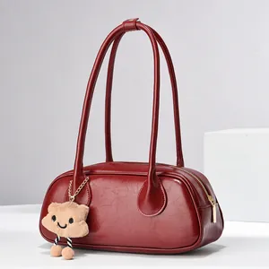 Retro wine red leather shoulder bag with sleek texture and plush doll charm pendant