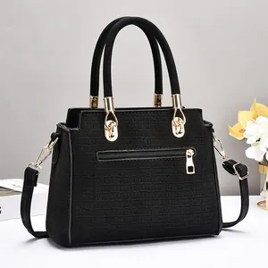Schwarze Handtasche mit Krokodilprägung, goldenen Details und verstellbarem Gurt