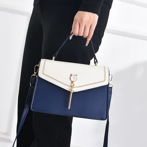 Modern color-block PU leather shoulder bag with cat-ear ornament and metal tassel