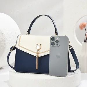 Chic color-block PU leather shoulder bag with cat-ear metal buckle and tassel charm