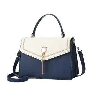 Chic color block shoulder bag in beige and navy blue with gold tassel and cat ear decor
