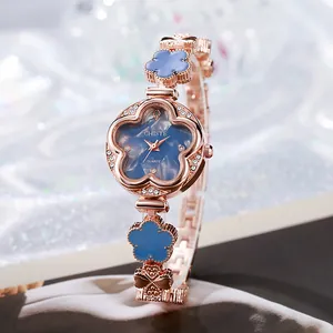 Vue macro d'une montre fleurie or rose avec lunette en cristal et cadran bleu marbré