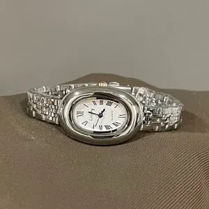 Close-up of vintage oval quartz watch with silver metal case and Roman numeral dial
