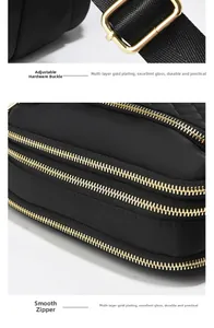 Macro detail of golden metal zippers and hardware on a black quilted crossbody bag
