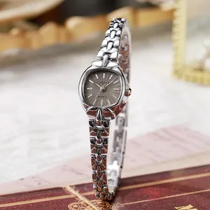 Macro shot of silver oval quartz watch dial with sunray texture on vintage background