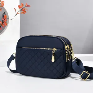 Navy quilted crossbody bag with golden zippers and multi-layer storage compartments