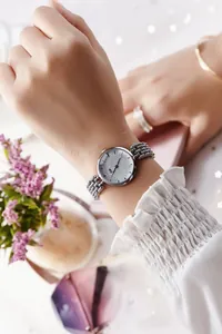 Gros plan d'une montre à quartz argentée avec cadran étoilé et bracelet à perles