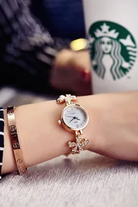 Detailed shot of a rose gold floral rhinestone watch with a classic screw-motif bangle
