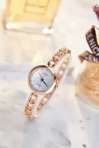 Detail of rose gold quartz watch featuring a chain strap and grey sunray dial
