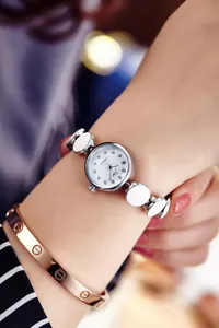 Nahaufnahme einer Damen-Quarzuhr mit weißem Zifferblatt und weißem Emaille-Gliederarmband