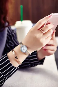 Close-up of a silver quartz watch with diamond bezel and link bracelet on woman's wrist