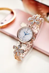Close-up of rose gold fashion watch featuring diamond-studded floral bracelet links
