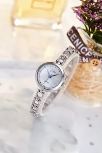 Detailed shot of lady quartz watch with silver steel chain band on marble background