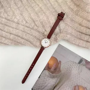 Detail view of ladies quartz watch with brown leather strap and rose gold round case