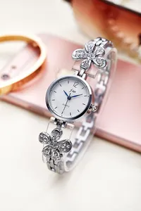 Detail of silver floral bracelet watch with crystals and blue hands on white dial
