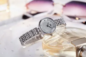 Vue rapprochée d'une montre argentée avec cadran pailleté et bracelet en perles