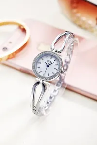 Detailed close-up of a silver fashion watch with rhinestones and hollow metal strap