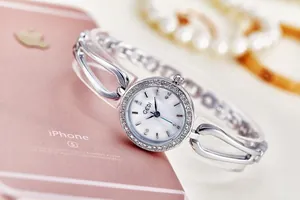 Close-up of GEDI silver steel watch with rhinestone bezel on a pearl necklace