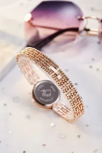 Détail du bracelet à perles or rose et du boîtier arrière en acier inoxydable pour montre femme
