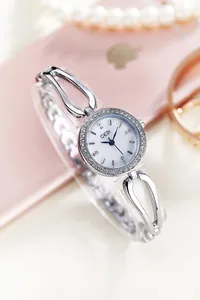 Detailed macro view of an elegant silver-tone quartz watch with diamond-set bezel
