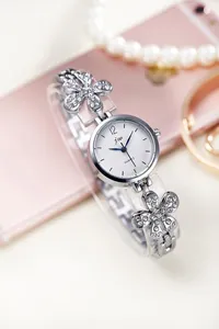 Close-up of women's quartz watch with sparkling rhinestone petal strap and pearl dial