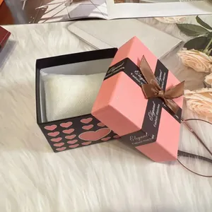 Pink and black watch gift box with heart patterns and elegant bow on plush background