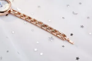 Detail of rose gold quartz watch with hollow chain bracelet on a starry tulle backdrop